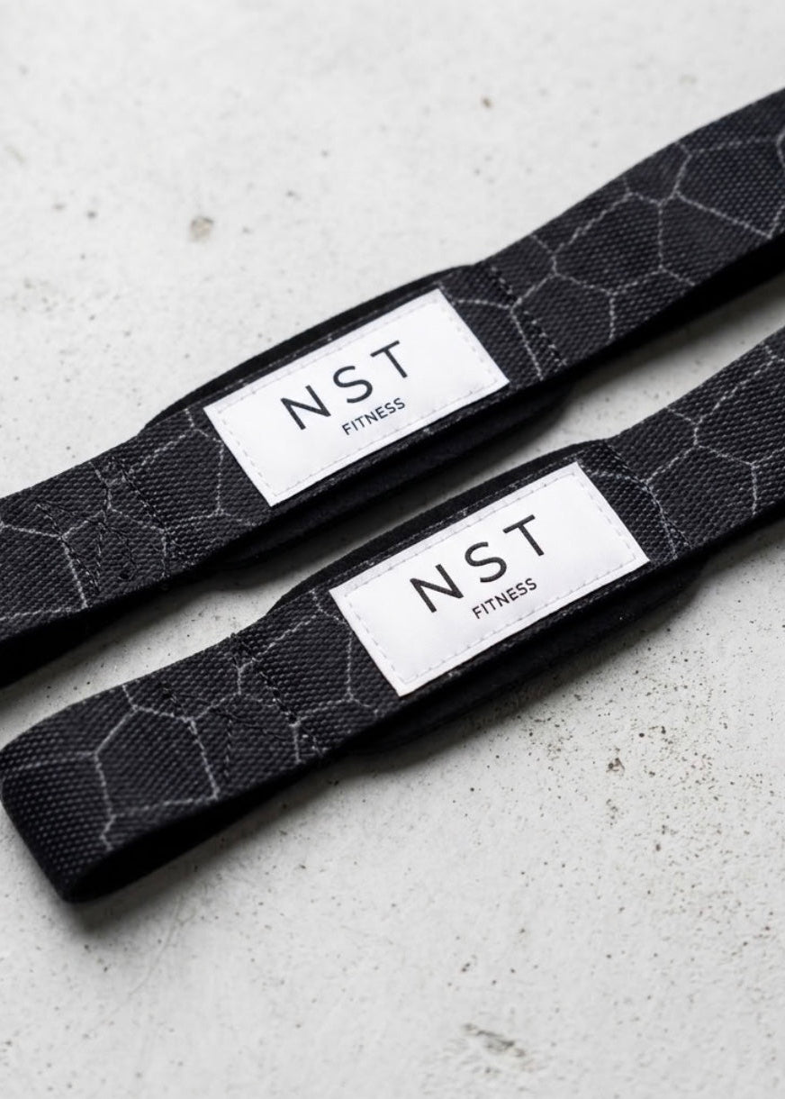 Schwarze Zughilfen von NST Fitness mit grauem Wabenmuster und weißem Logo-Label für Krafttraining und Gewichtheben.