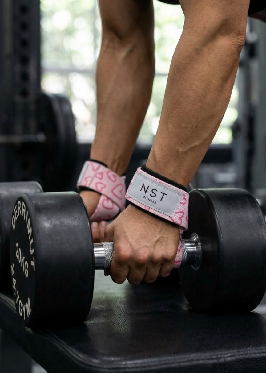 NST Fitness Zughilfen im pinken Herzdesign beim Krafttraining mit Kurzhanteln im Gym.