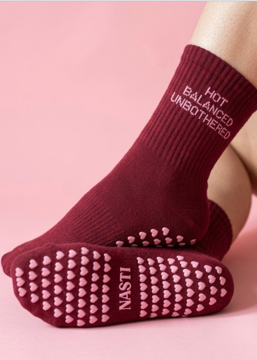 Burgundy Socken mit einer pinken Schrift "Hot,Balanced, Unbothered" und Herz Noppen