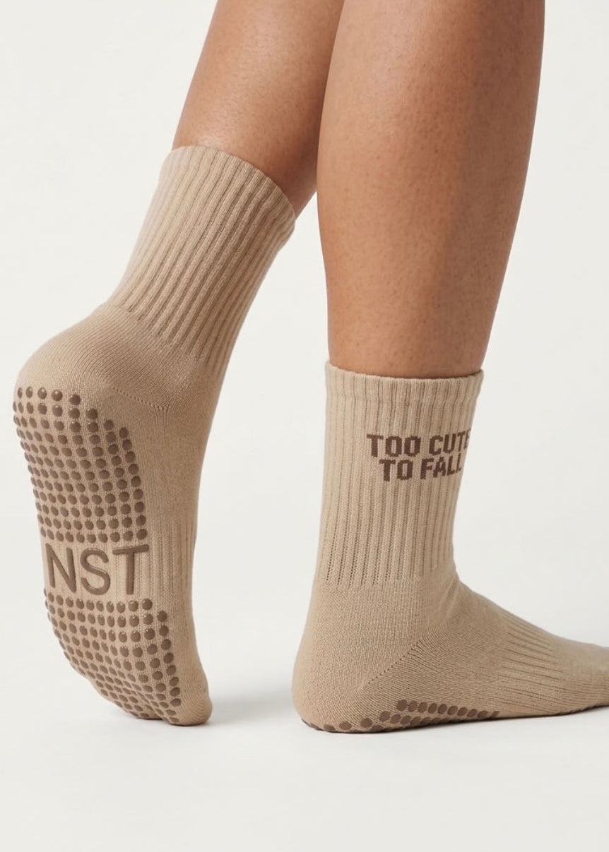 Hell braune Pilates Socken mit einer dunkel braunem Schriftzug "Too cute to fall"