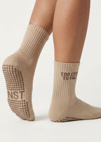 Hell braune Pilates Socken mit einer dunkel braunem Schriftzug "Too cute to fall"