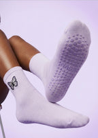 Hell Lila Socken mit einem eingestickten Schmeterling und punkte als Noppen