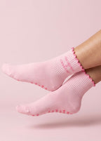 Pinke Pilates Socken mit einem Rüschenrand un der Schrift "Gorgeous & Grounded"