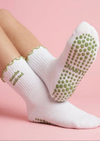 Weiße Pilates Socken mit einem grünen Rüschenrand und einer Schrift die sagt "Matcha Addicted". Die Sohle hat grüne Noppen
