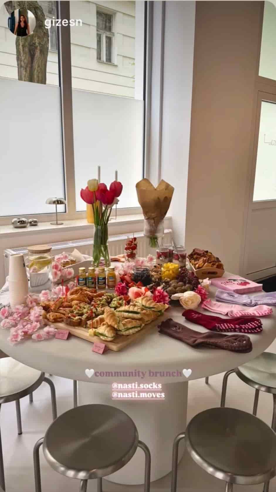Festlich dekorierter Brunch-Tisch mit Blumen, Gebäck, Snacks, Getränken und verschiedenen NST Socks für ein Community-Event.
