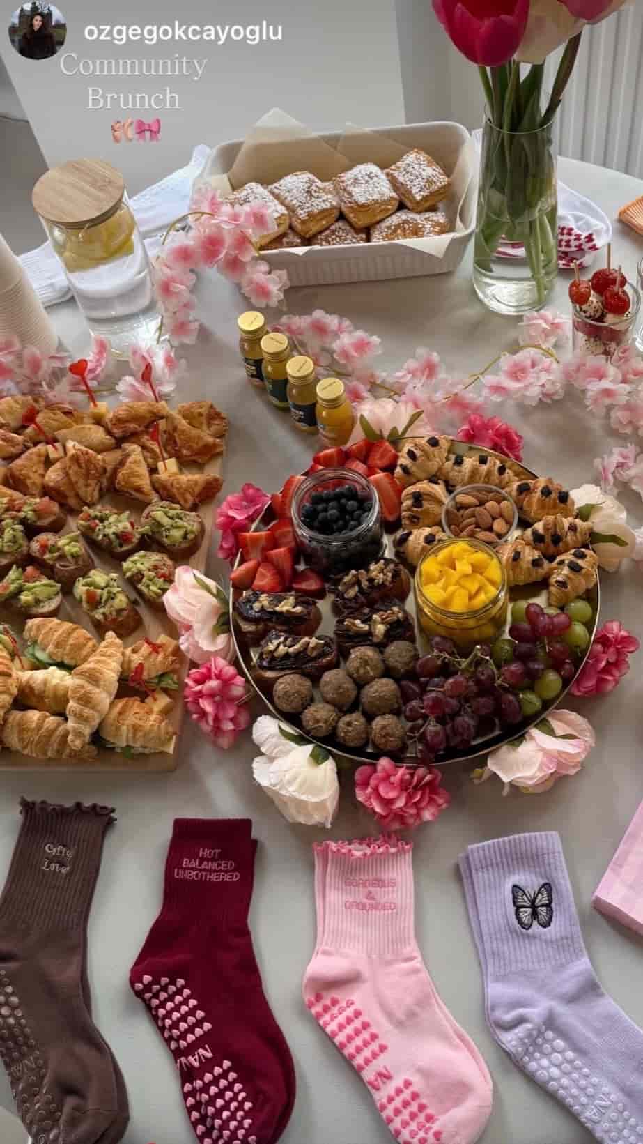 NST Pilates Grip Socks in verschiedenen Farben und Designs auf einem liebevoll dekorierten Community-Brunch-Tisch mit frischem Gebäck, Obst und Blumen