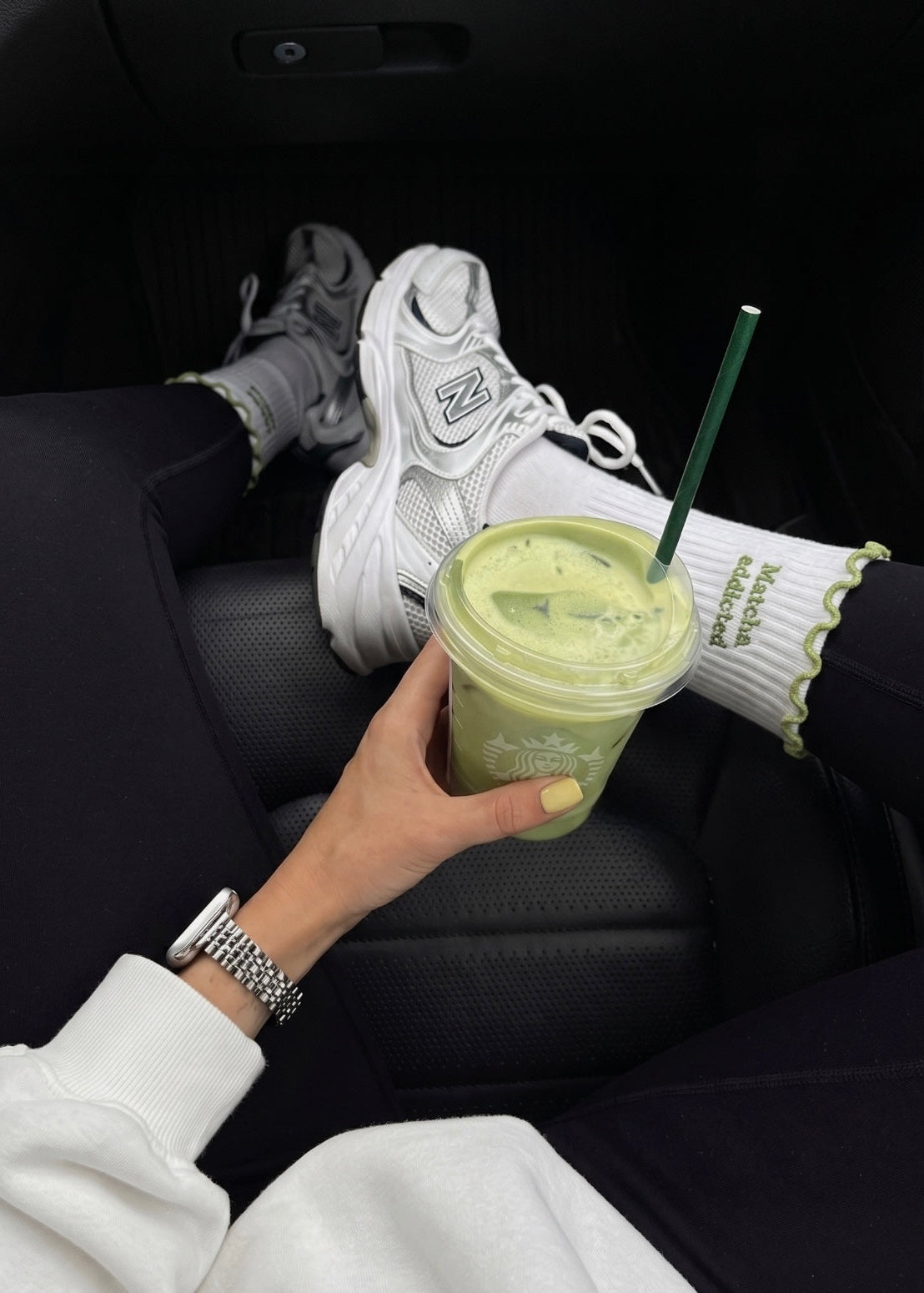 Weiße Pilates socken mit weißen Senaker und eine Frau die einen Matcha in der Hand hält