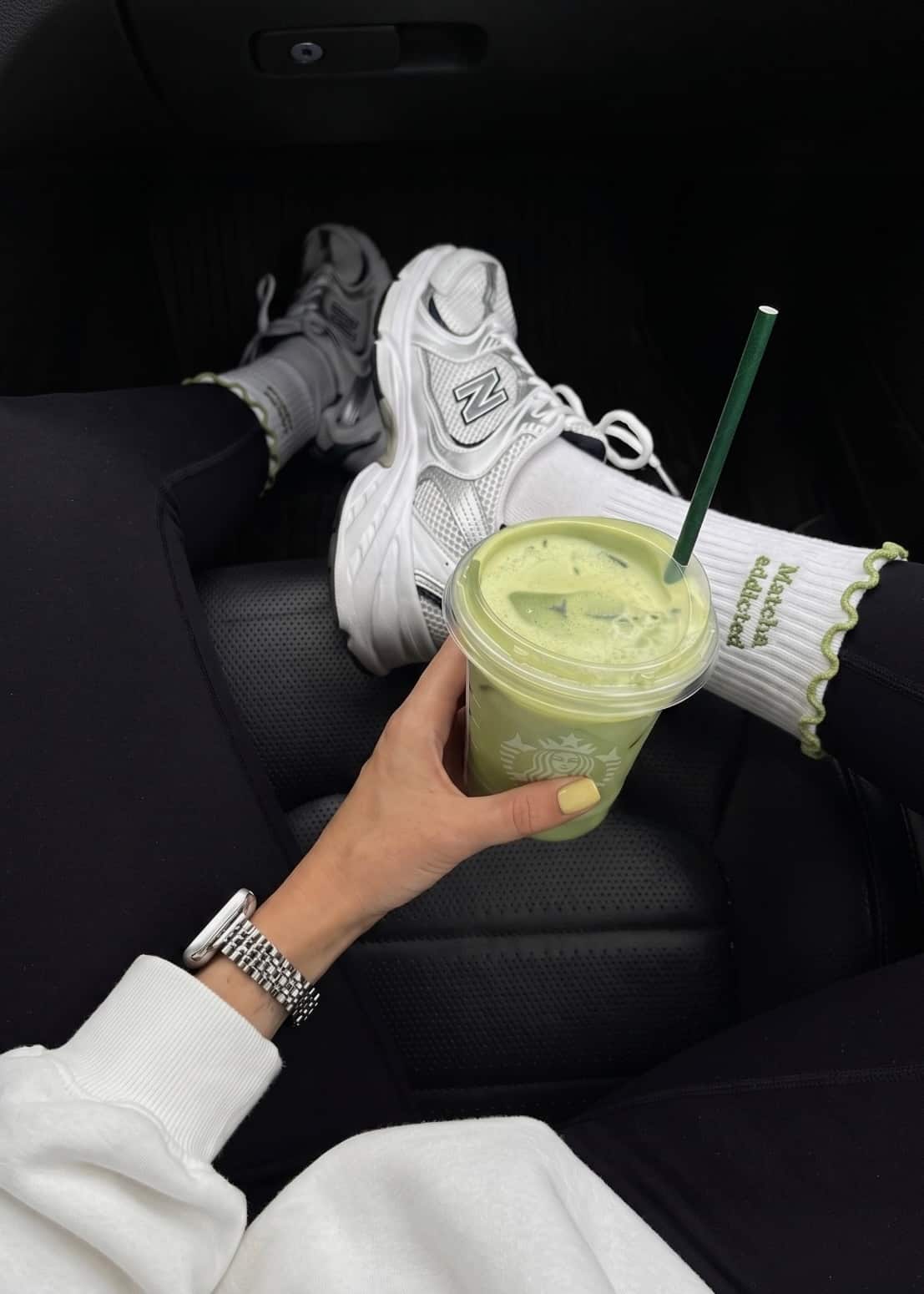 Weiße Pilates socken mit weißen Senaker und eine Frau die einen Matcha in der Hand hält